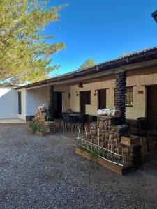 a building with a pile of logs in front of it at Hostal Piedrita de Rio in San Pedro de Atacama