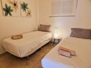 two twin beds in a room with a lamp at La Cala de Mijas, groundfloor 2 bed apartment steps away from the beach in Mijas Costa +21 photos