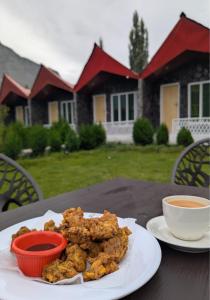 a plate of food on a table with a cup of coffee at Comfort Hotel & Huts in Skardu