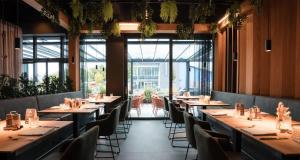 a restaurant with long tables and chairs and windows at Best Western Hotel am Europaplatz in Königsbrunn