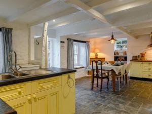 a kitchen with a sink and a table with chairs at 2 Bed in Polruan oc-pc033 in Fowey