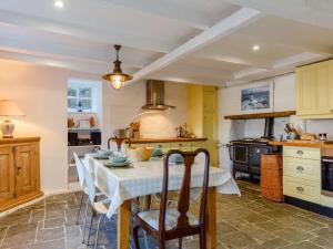 a kitchen with a table with chairs and a stove at 2 Bed in Polruan oc-pc033 in Fowey