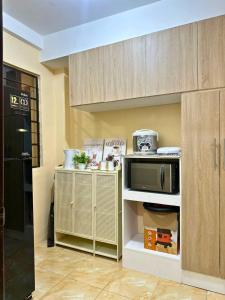 a kitchen with a microwave on a shelf next to a wall at Luxy Stay Gensan in Lagao II