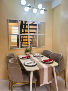 a dining room with a table with chairs and a mirror at Luxy Stay Gensan in Lagao II +13 photos