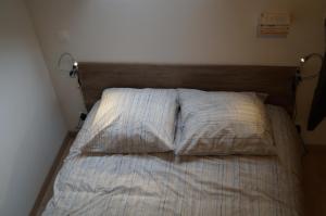an unmade bed in a bedroom with two pillows at L'atelier in Cancale