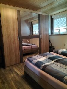 a bedroom with two beds and a mirror at Ferienwohnung Naturblick in Schönhagen +12 photos