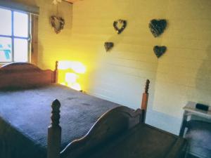 a bedroom with a bed with hearts on the wall at Trevenna Cabin in St Austell