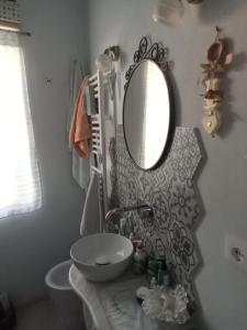 a bathroom with a sink and a mirror on the wall at La Petite Maison in Campagnatico