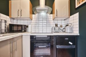 a kitchen with a sink and a stove at The Snug @ Clarence in Derry Londonderry