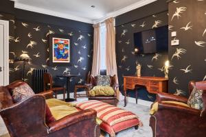 a living room with black walls with birds on the wall at The Snug @ Clarence in Derry Londonderry