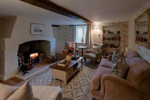 a living room with a couch and a fireplace at Master Builder's House Hotel in Beaulieu