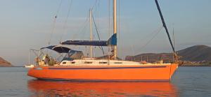 an orange sail boat sitting in the water at kaisi in Fanari