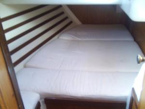 a small bed with white sheets in a small room at kaisi in Fanari