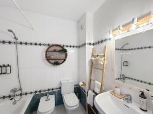 a bathroom with a toilet and a sink and a tub at Apartamento con piscina SS20 in Fornells