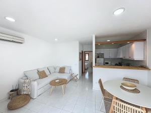 a living room with a white couch and a table at Apartamento con piscina SS20 in Fornells