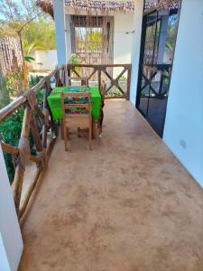 a room with a table and chairs on a balcony at Sunset Lover in Michamvi