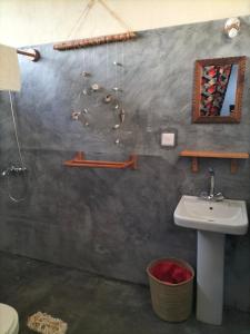 a bathroom with a sink and a toilet and a mirror at Sunset Lover in Michamvi +37 photos