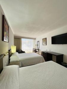 a hotel room with two beds and a television at Hotel Arroyo de la Plata in Zacatecas