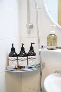 a shelf in a bathroom with three bottles of soap at Moonjarak Dalbit Hanok in Seoul +87 photos