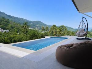 ein Schwimmbecken mit einer Schaukel und einem Stuhl daneben in der Unterkunft BRW Samui in Bophut 