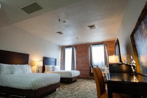 a hotel room with two beds and a desk at The Inn Down Town in Erie