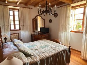 a bedroom with a bed and a mirror and a chandelier at Casa Conchas in Ferreira