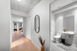 a bathroom with a toilet and a sink and a mirror at Tromso Downtown Apartments - Main Street in Tromsø +58 photos