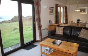 a living room with a couch and a coffee table at Heather Cottage in Lairg