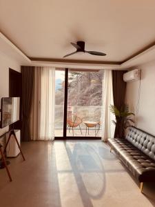 a living room with a couch and a large window at Radiance Stay in Paengnodam