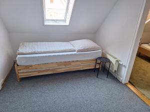 a bed in a small room with a small stool at Delblaiso Suite in Memmingen