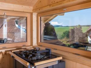 a stove in a tiny house with a large window at Saunaloft Schwarzwald - privater 45qm Saunabereich - großzügige Räume mit viel Ruhe in Gemeinde Aichhalden