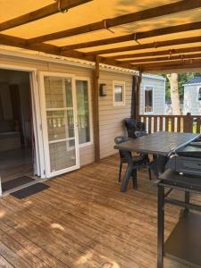 a screened porch with a table and a picnic table at Le Cocon Landais in Capbreton