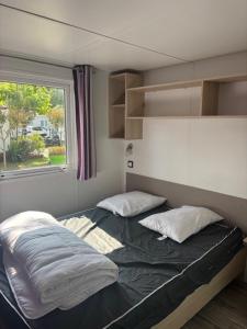 a small bedroom with a bed and a window at Le Cocon Landais in Capbreton
