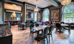 a restaurant with tables and chairs in a room at White Hart Hotel & Apartments in Harrogate