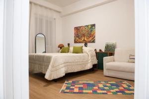 a bedroom with a bed and a couch and a chair at via Minzoni 26 in Cosenza