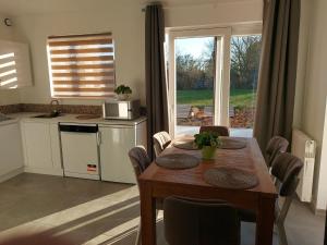 a kitchen with a wooden table and a kitchen with a microwave at Au pays des cigognes in Cambron-Casteau