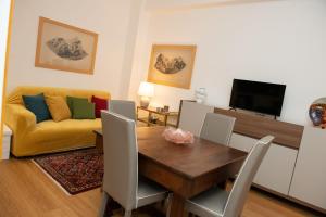 a living room with a table and a yellow couch at via Minzoni 26 in Cosenza