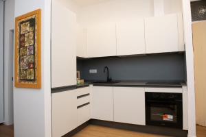 a kitchen with white cabinets and a sink at via Minzoni 26 in Cosenza