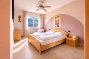 a bedroom with a large bed with a ceiling fan at Mont&Lac Lake View Apartment in Limone in Limone sul Garda
