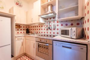 a small kitchen with white cabinets and a microwave at Mont&Lac Lake View Apartment in Limone in Limone sul Garda