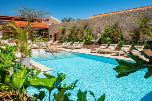 a swimming pool with lounge chairs and a resort at Praia Hotel Imbituba in Imbituba