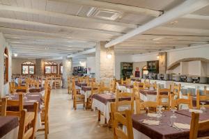 a restaurant with tables and chairs in a room at Club Esse Posada in Palau