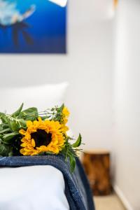 a bouquet of sunflowers sitting on top of a bed at MNS Accommodations in Salamina