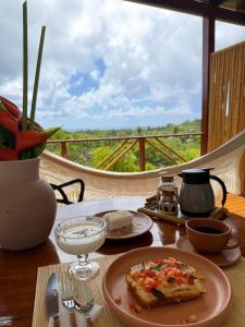 a plate of pizza on a table with a view at Pousada Almaré Boipeba in Ilha de Boipeba