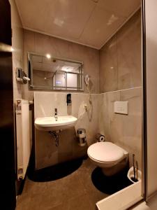 a small bathroom with a toilet and a sink at Hotel Augustin Komfort Leipzig in Leipzig