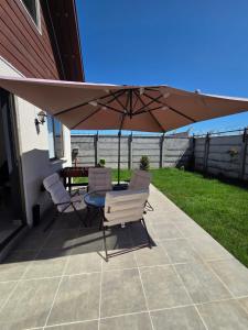 a patio with a table and chairs under an umbrella at Cómoda casa con 3 habitaciones de lujo en Talca in Talca
