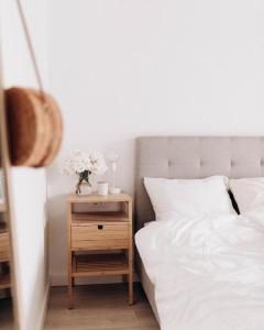 a bed with white sheets and a nightstand with a table with a vase at Villa Sunrise Labin Istria - a smile every day in Nedeščina +32 photos