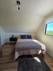 a bedroom with a bed with blue pillows and a window at Cómoda casa con 3 habitaciones de lujo en Talca in Talca