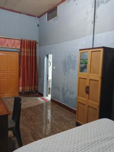 a bedroom with a bed and a wooden cabinet at Keluncing Field Homestay in Kotaraja