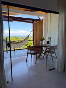 a dining room with a table and a large window at Pousada Almaré Boipeba in Ilha de Boipeba